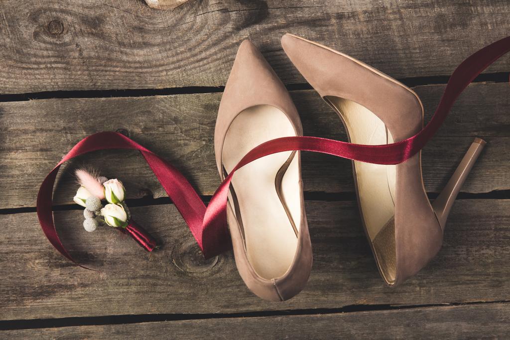 top view of beautiful bridal shoes and corsage on wooden tabletop - Photo, Image