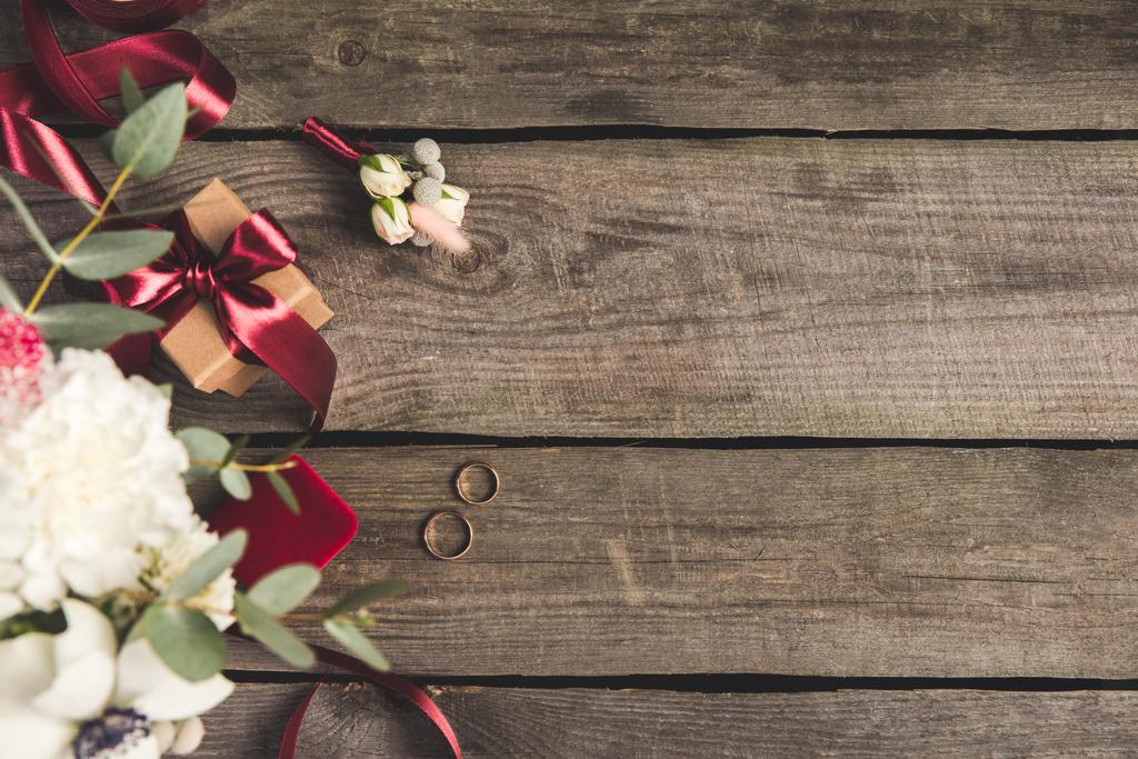 plano con anillos de boda, joyero, ramo de novia y ramillete en la mesa de madera
 - Foto, imagen