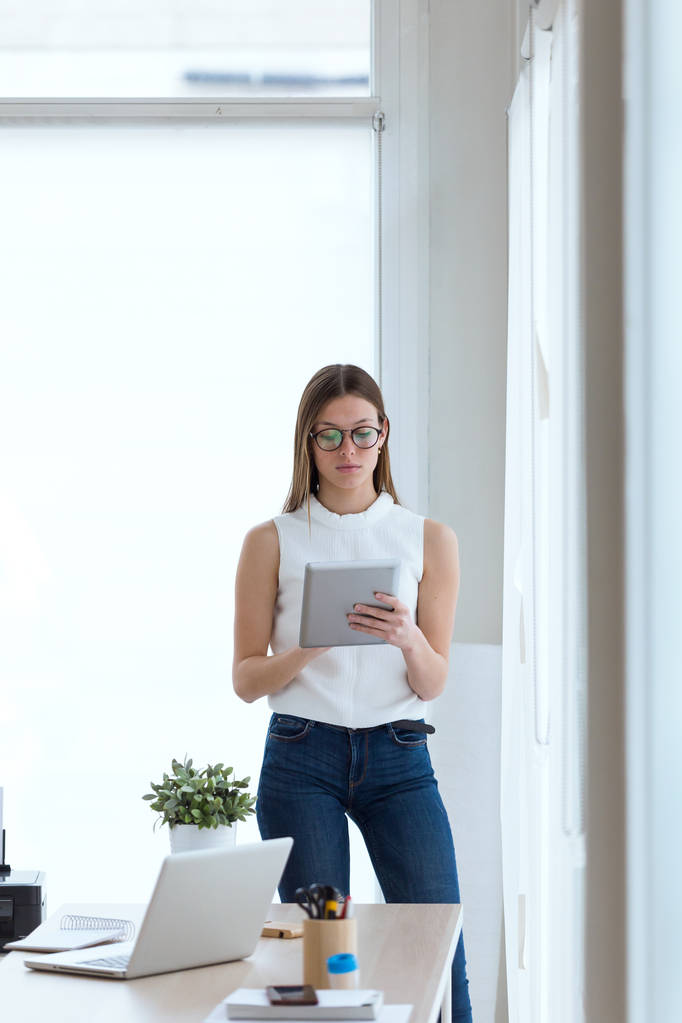 Business giovane donna utilizzando il suo tablet digitale in ufficio
. - Foto, immagini