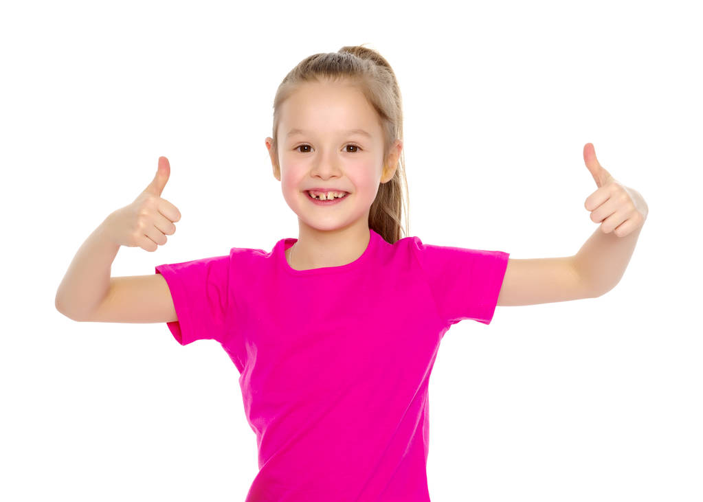 Klein meisje houdt haar duim omhoog - Foto, afbeelding