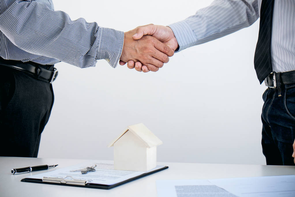 Kredyt mieszkaniowy ubezpieczenie koncepcja, broker agenta uścisk dłoni z cus - Zdjęcie, obraz