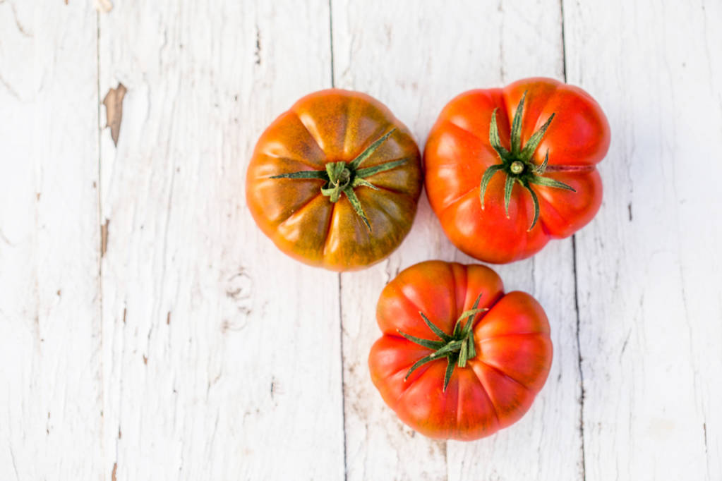 Close-up van verse, rijpe tomaten op witte houten achtergrond met kopie ruimte. bovenaanzicht. Voedsel pagina - Foto, afbeelding