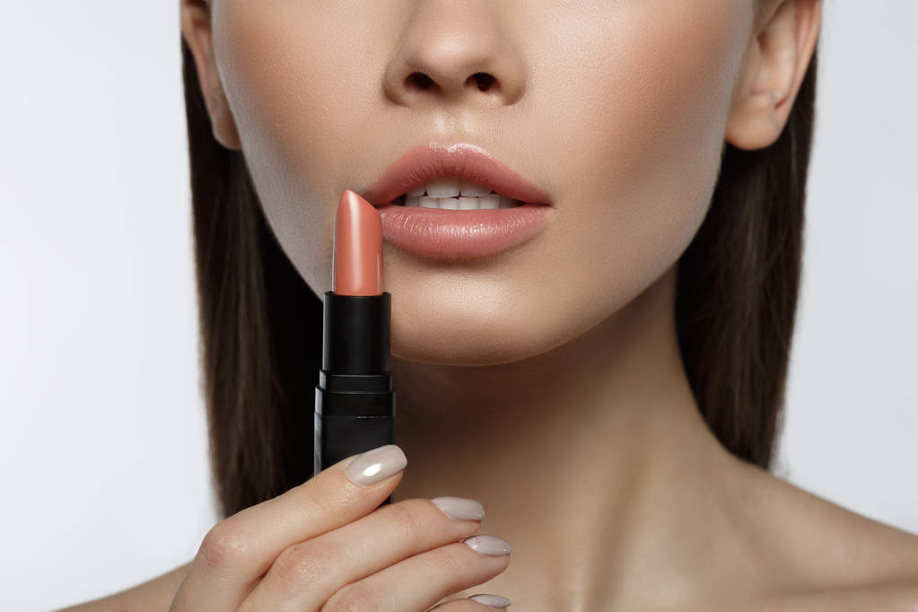 Mujer joven sensual aplicando color en los labios
 - Foto, imagen