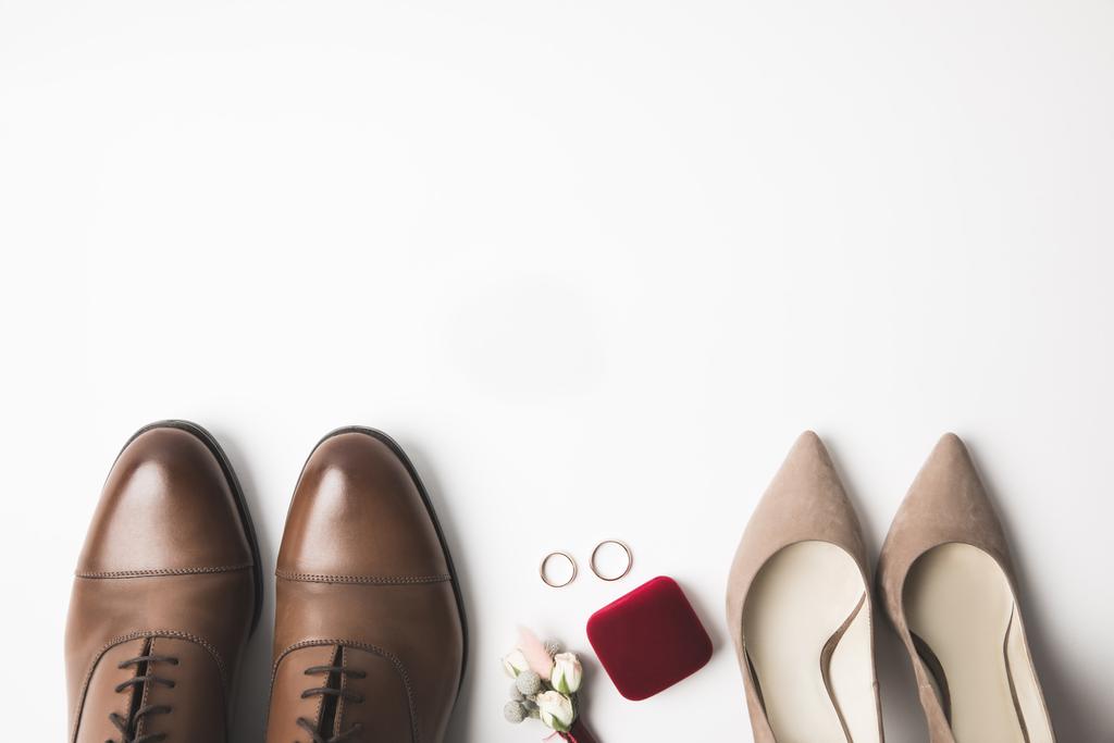 верхний вид пар жениха и невесты обувь, букетик, ювелирная коробка и обручальные кольца изолированы на белом
 - Фото, изображение