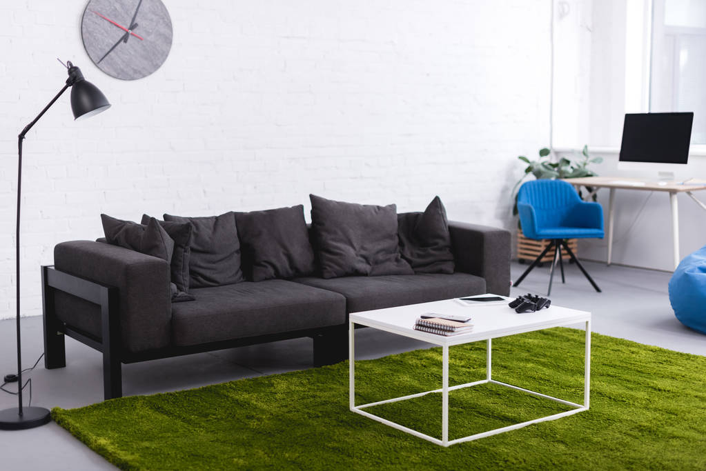 canapé gris et tapis vert avec tables dans le salon
 - Photo, image