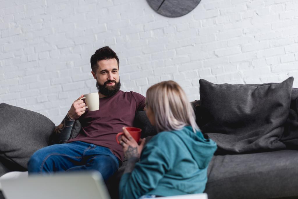 couple tatoué boire du café et regarder les uns les autres à la maison
 - Photo, image