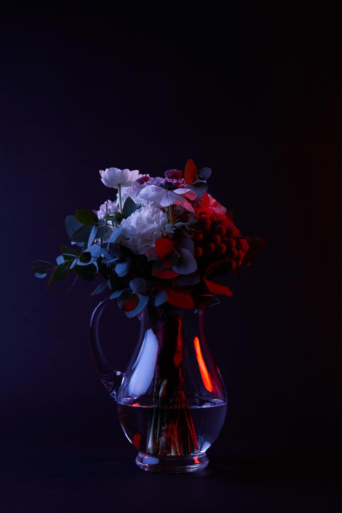 bouquet of different flowers in reflecting glass vase on dark - Photo, Image