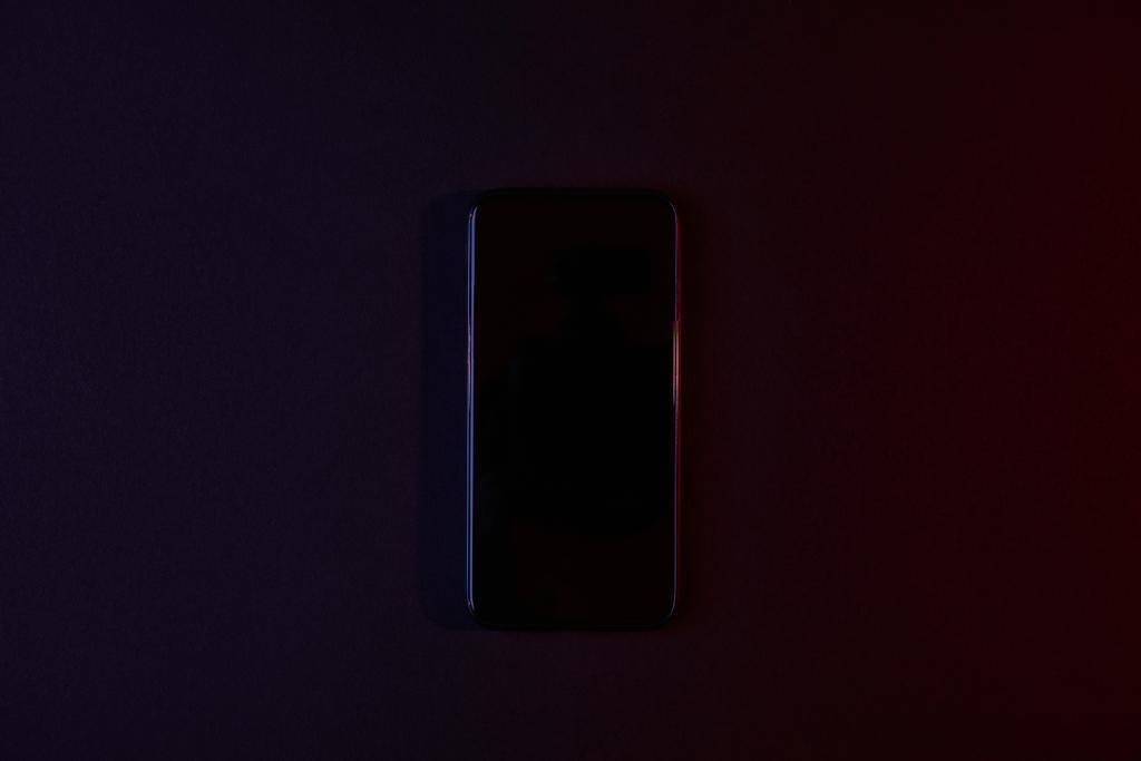 κάτοψη του μαύρου smartphone στο σκοτάδι - Φωτογραφία, εικόνα