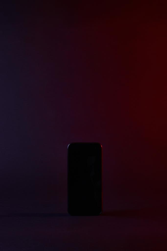 υπερυψωμένη θέαση του ένα μαύρο smartphone στο σκοτάδι - Φωτογραφία, εικόνα