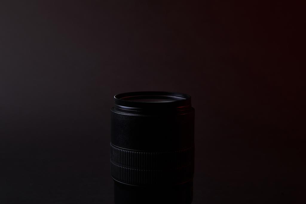 одиночный оптический объектив на темной поверхности
 - Фото, изображение
