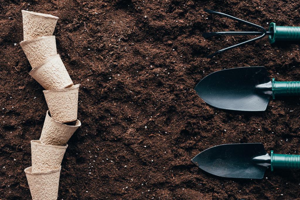 top view of empty flower pots and small gardening tools on soil - Photo, Image