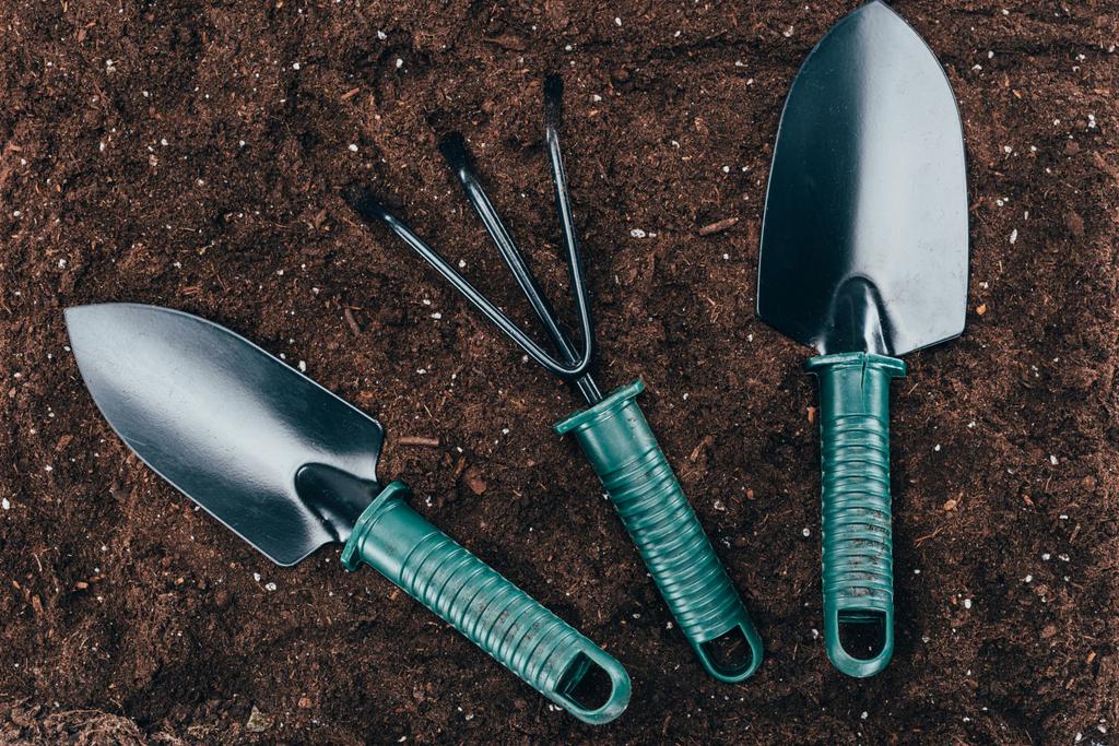 vista superior de pequenas ferramentas de jardinagem no solo
 - Foto, Imagem