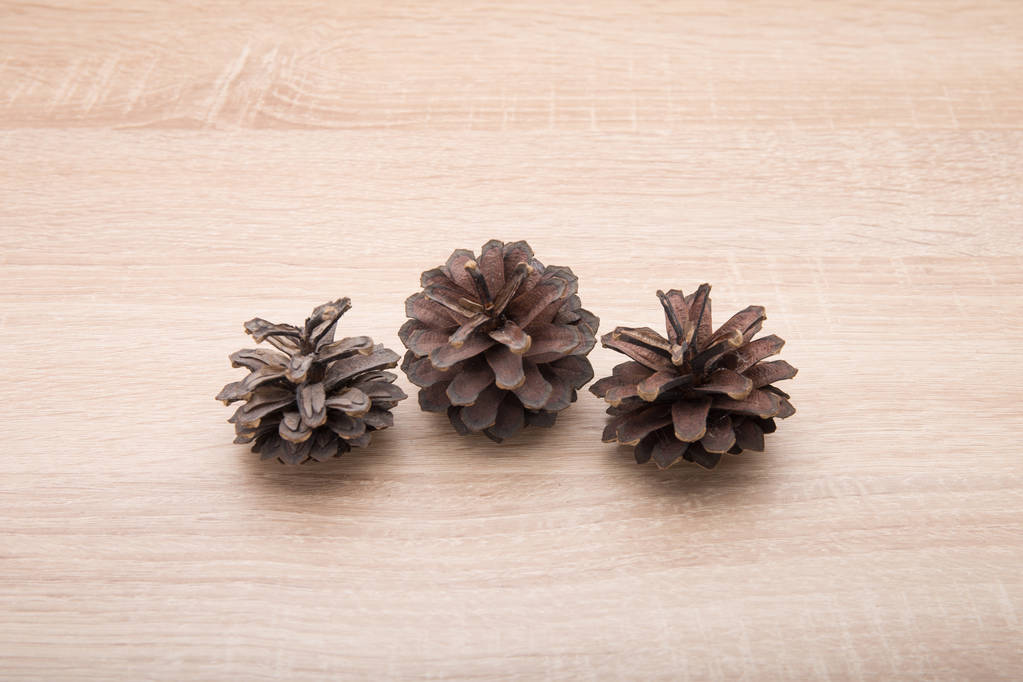 Conos de pino sobre fondo de madera
 - Foto, Imagen