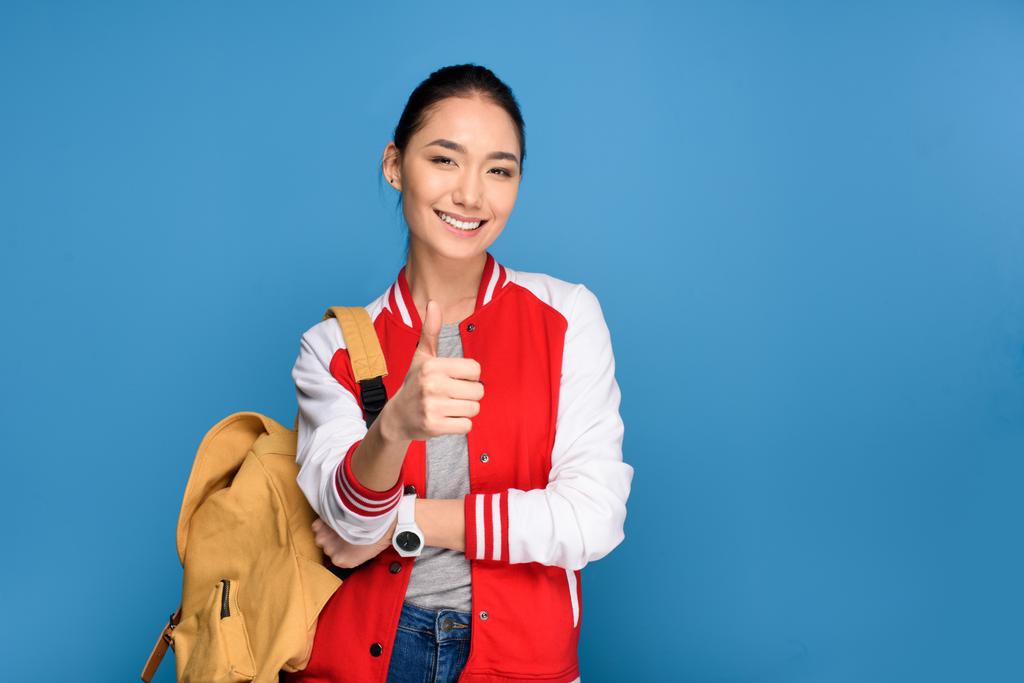 retrato de sorrindo asiático estudante mostrando polegar para cima isolado no azul
 - Foto, Imagem