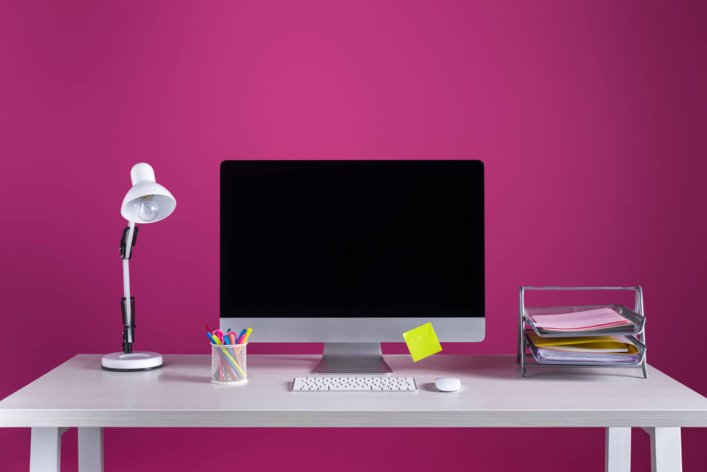 空白の画面、事務用品やピンクのテーブルの上にランプとデスクトップ コンピューター - 写真・画像
