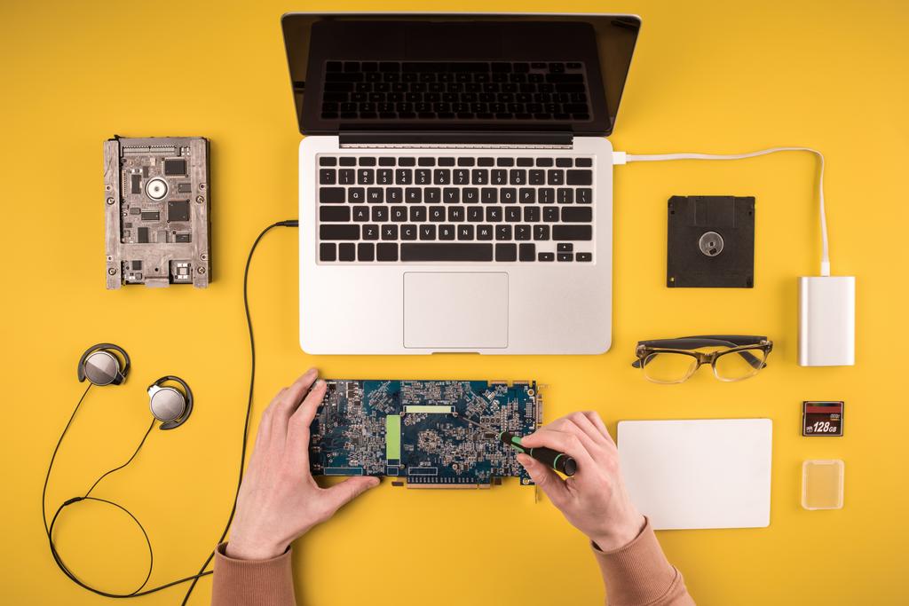 vista superior parcial de la persona que fija el ordenador portátil en amarillo
  - Foto, imagen