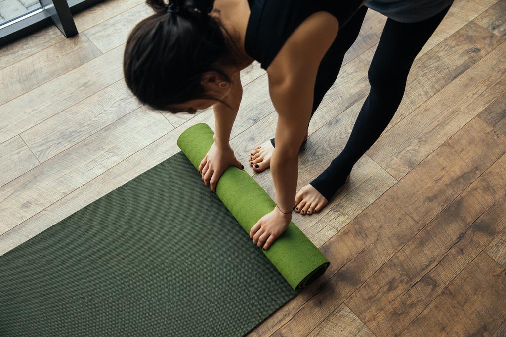 visão de alto ângulo da menina colocando tapete de ioga no chão
  - Foto, Imagem