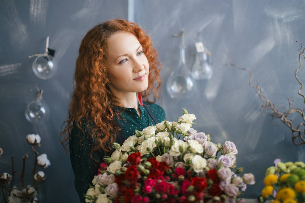 赤と白のバラの花束を持って魅力的な外観を持つ店員 - 写真・画像