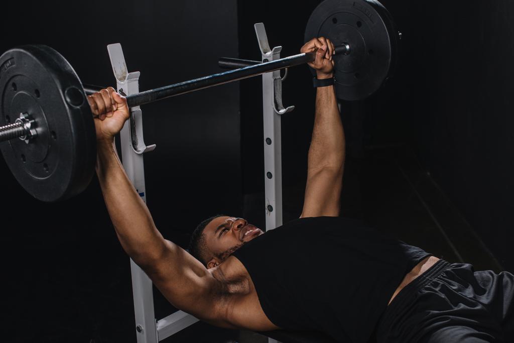 バーベルを持ち上げる筋肉の若いアフリカ系アメリカ人のスポーツマン  - 写真・画像