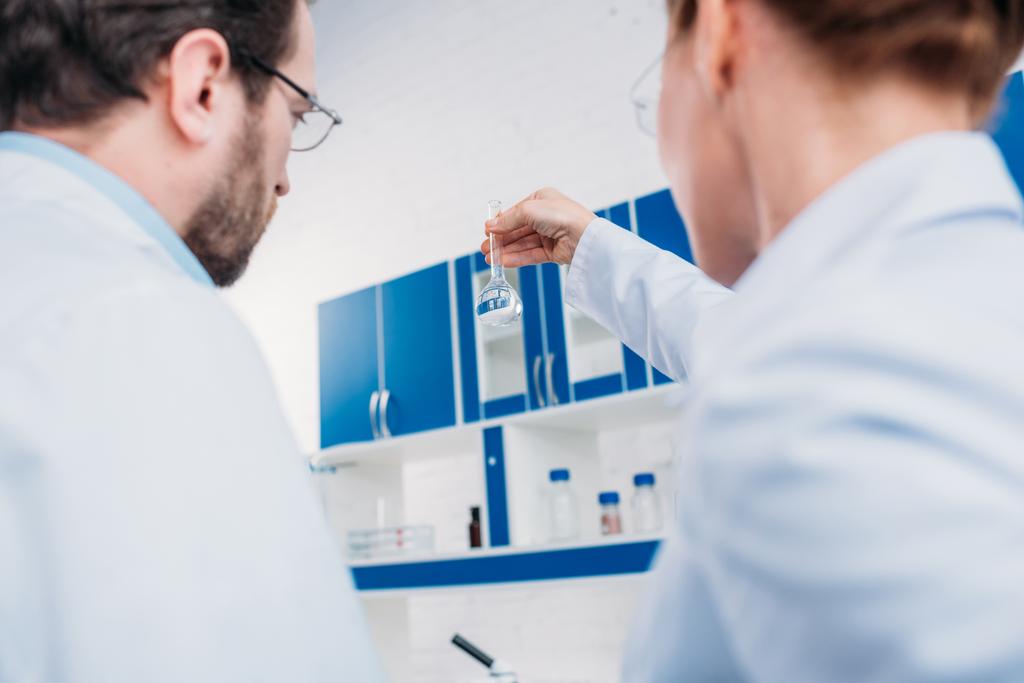 研究室の試薬でチューブを見て白衣の科学者の背面図 - 写真・画像