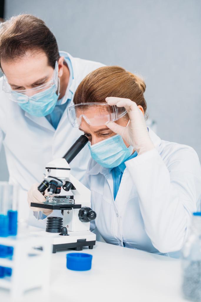 vědci v bílých pláštích, lékařské rukavice a brýle, společně dělat vědecký výzkum v laboratoři - Fotografie, Obrázek
