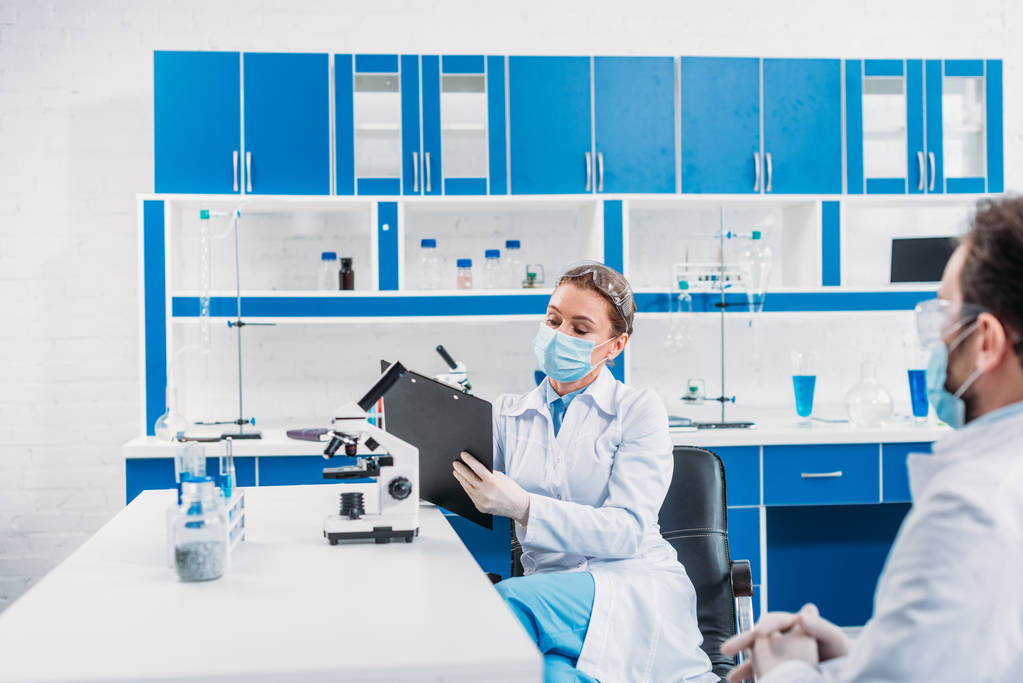 частковий погляд науковців на білі пальто на робочому місці в лабораторії
 - Фото, зображення