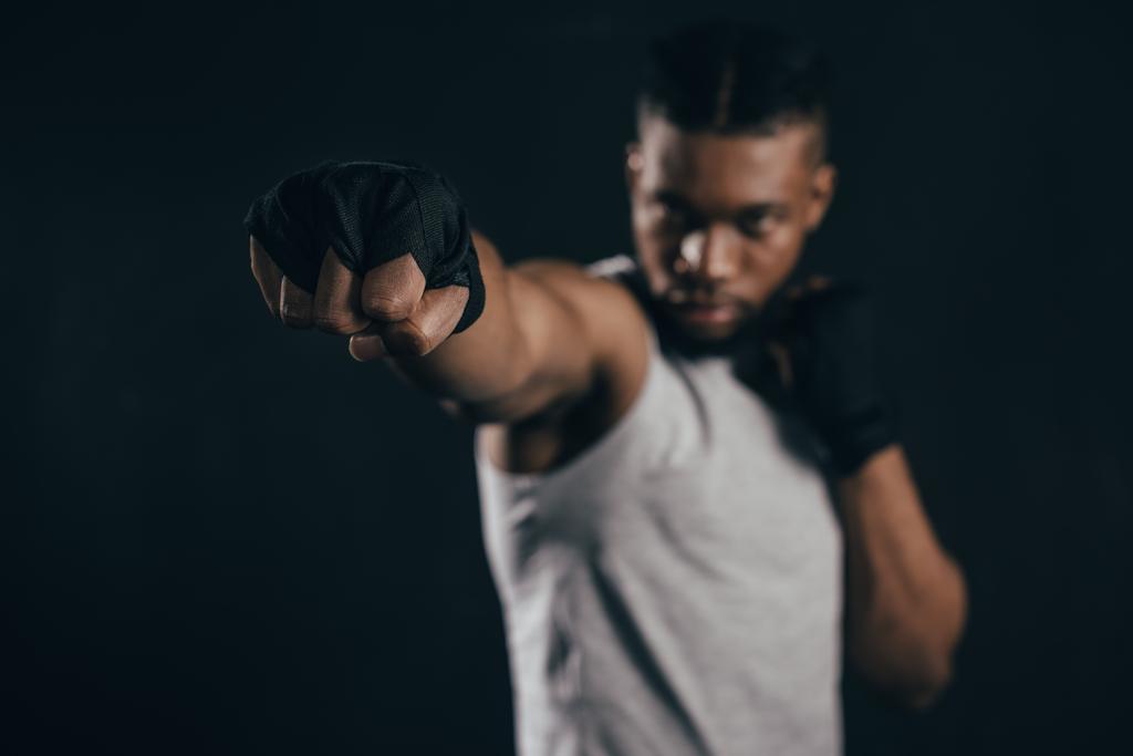 close-up view of young african american kickboxer training on black - Photo, Image