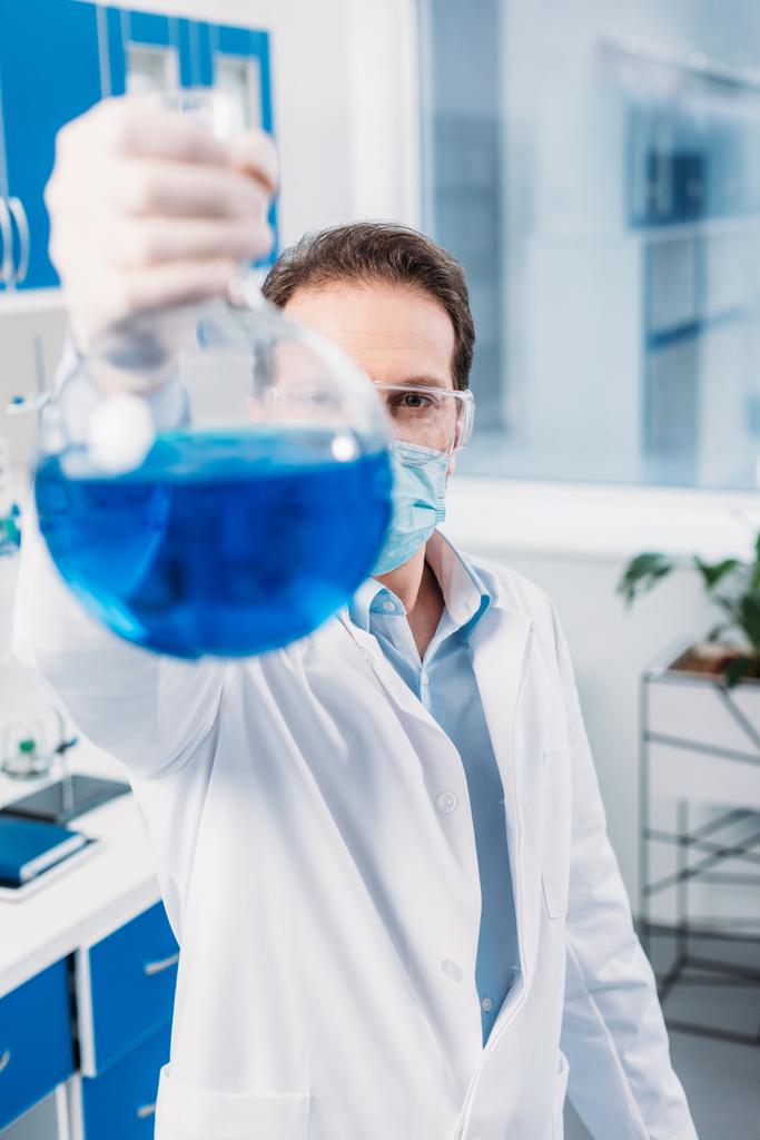 Selektiver Fokus des Wissenschaftlers mit der Flasche in der Hand im Labor - Foto, Bild