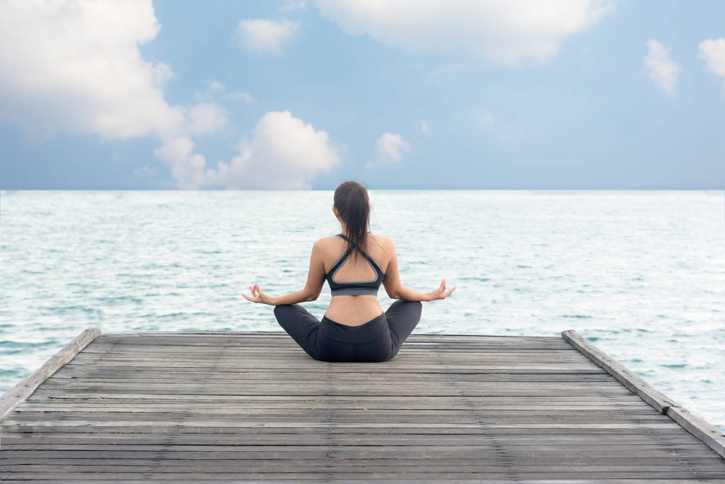 Sağlıklı kadın yaşam tarzı meditasyon dengeli yoga uygulamak ve enerji Köprüsü'nde otelde sabah deniz kıyısı. Sağlıklı kavramı - Fotoğraf, Görsel