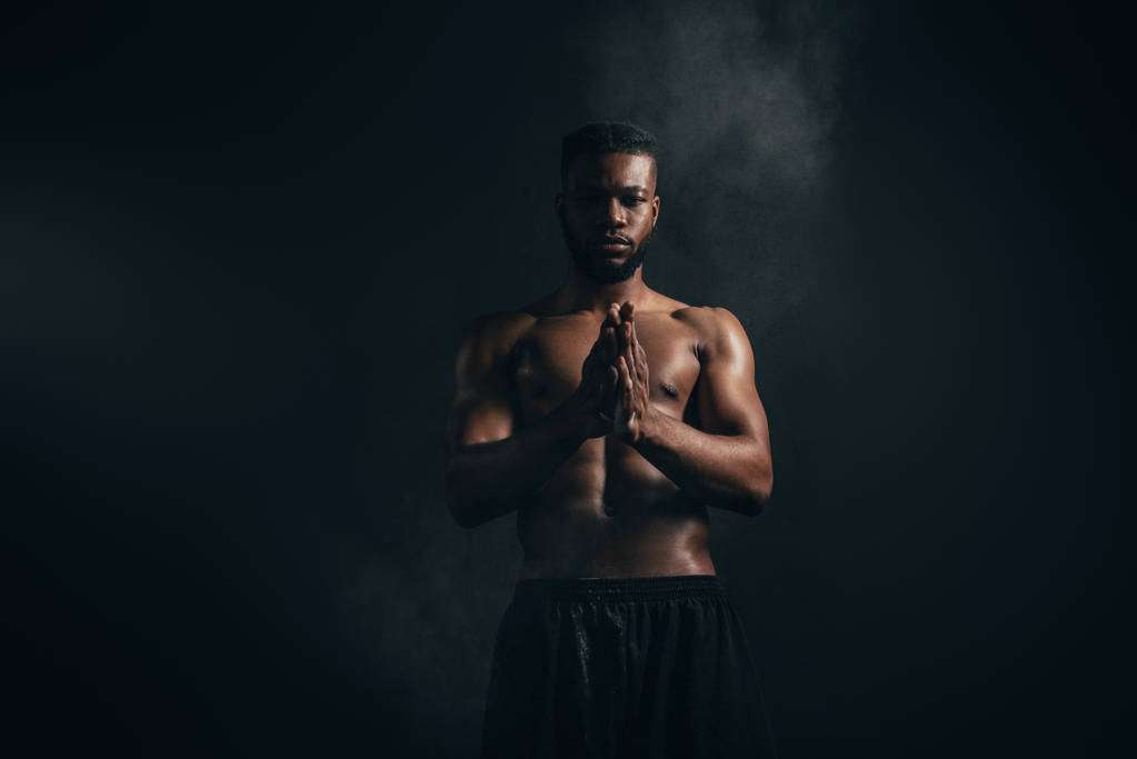 νεαρός αφρικανική αμερικανική Αθλητικός τύπος εφαρμογή ταλκ και κοιτάζοντας την κάμερα στο μαύρο    - Φωτογραφία, εικόνα