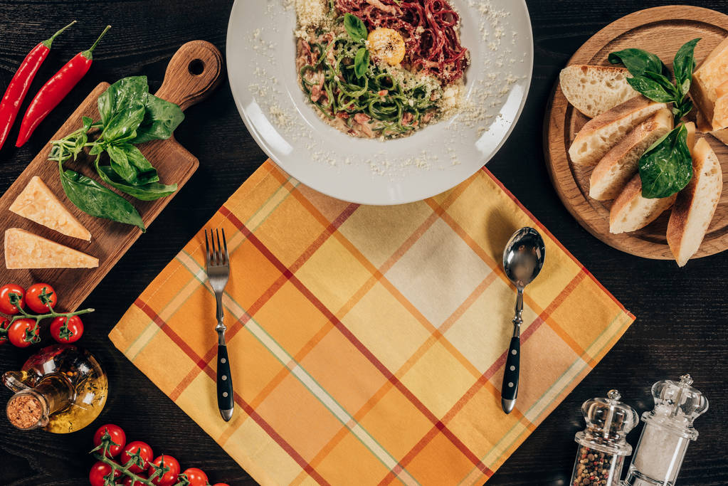 ylhäältä lautaselle spagetti, haarukka ja lusikka pöydällä
 - Valokuva, kuva