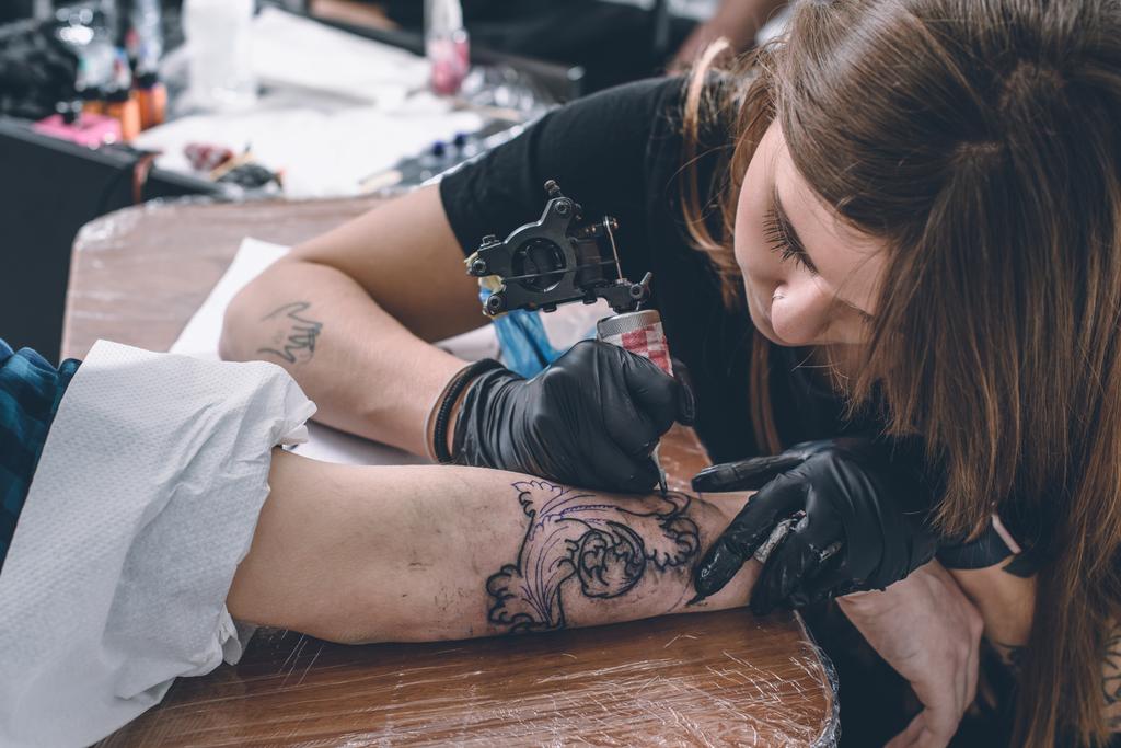 Γυναικεία τατουάζ πλοίαρχος κατά τη διάρκεια της εργασίας στο στούντιο - Φωτογραφία, εικόνα