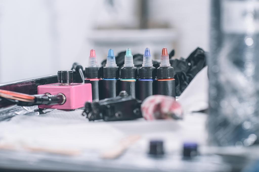 Τατουάζ μηχάνημα και μπουκάλια με πολύχρωμο μελάνι  - Φωτογραφία, εικόνα