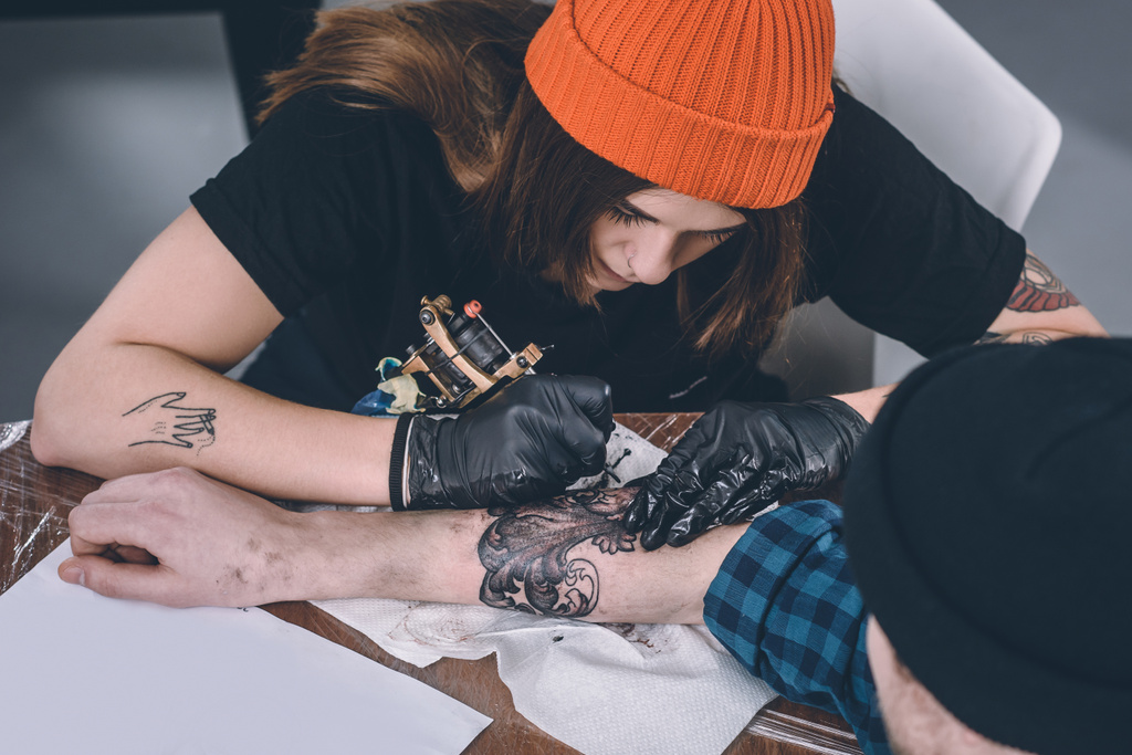 Chlapce a ženy tetování master během tetování ve studiu - Fotografie, Obrázek