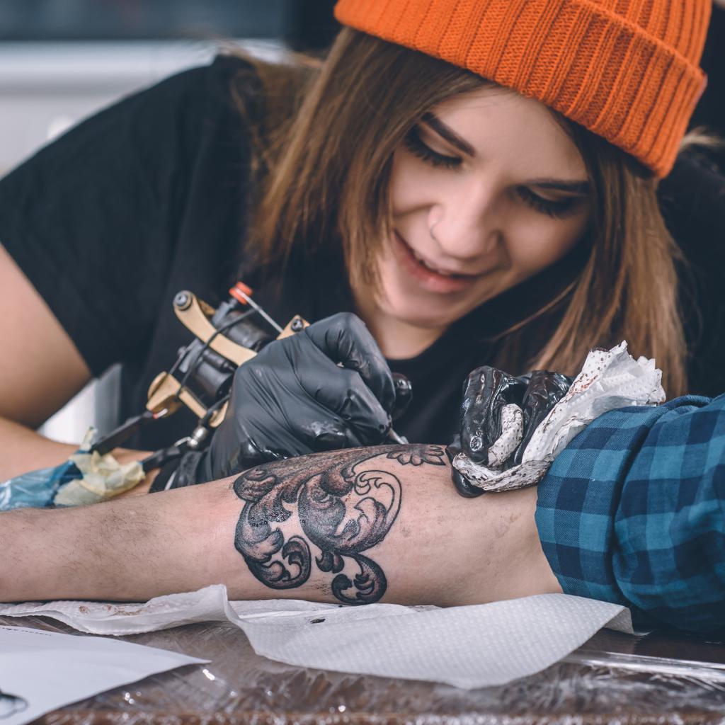 Lähikuva naisten tatuointi master käsineet työskentelevät käsivarsi pala
 - Valokuva, kuva
