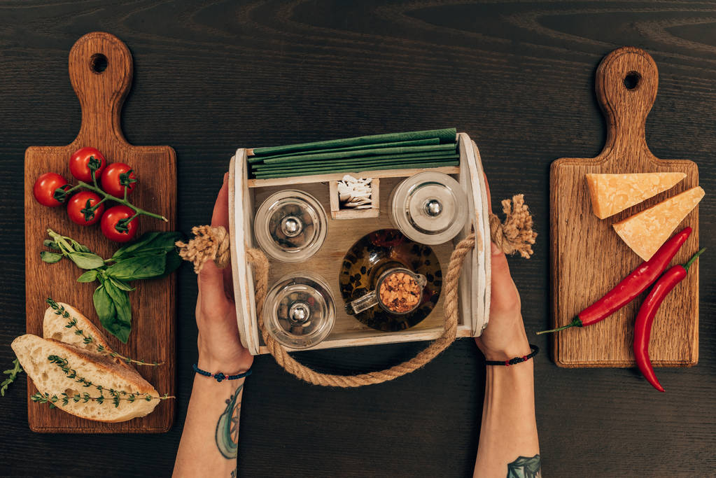 rajattu kuva nainen tilalla puinen laatikko oliiviöljyä ja pippuria hiomakone
 - Valokuva, kuva