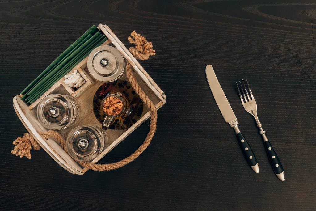 bovenaanzicht van houten doos met olijfolie en peper grinder op houten tafel - Foto, afbeelding
