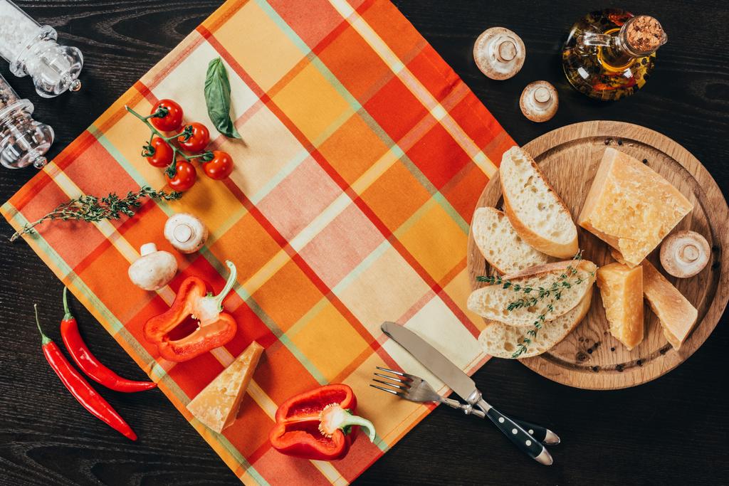 felülnézet tábla szalvéta zöldségekkel és vágódeszka, parmezán sajt asztalra - Fotó, kép