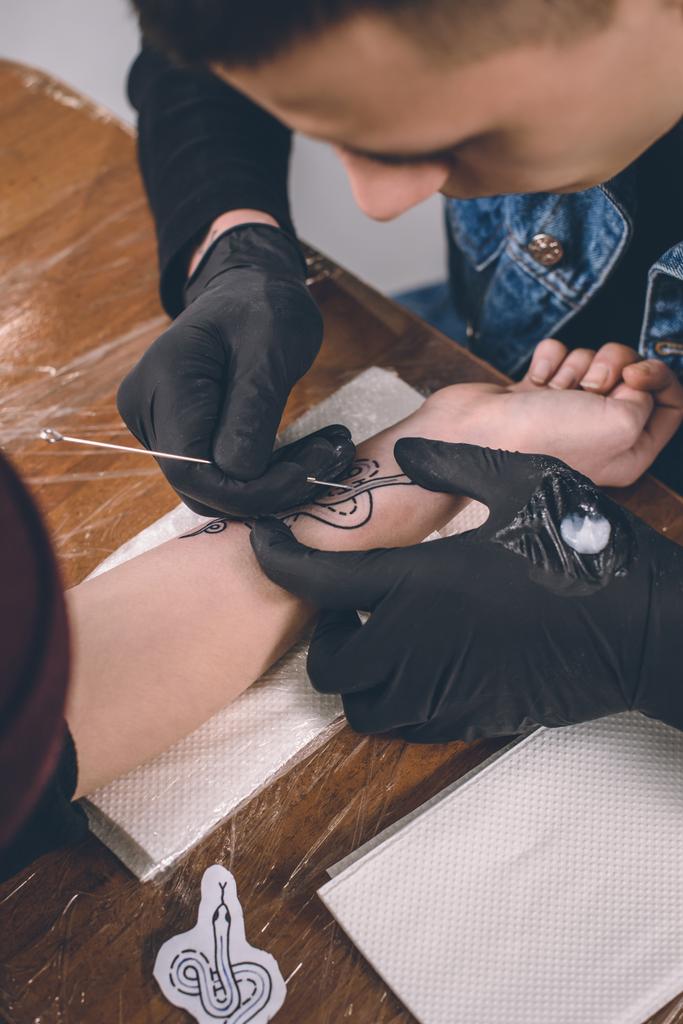 Artysta tatuażu w rękawiczkach pracy w studio - Zdjęcie, obraz