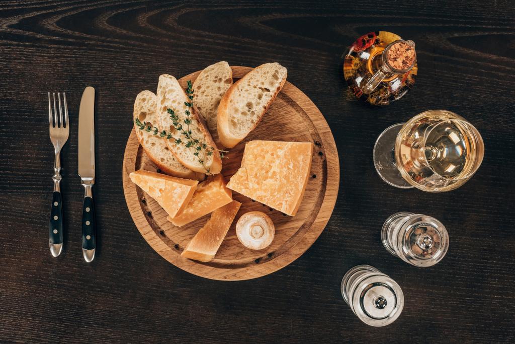 vista superior del queso parmesano con rodajas de baguette y champiñones sobre tabla de madera
 - Foto, imagen