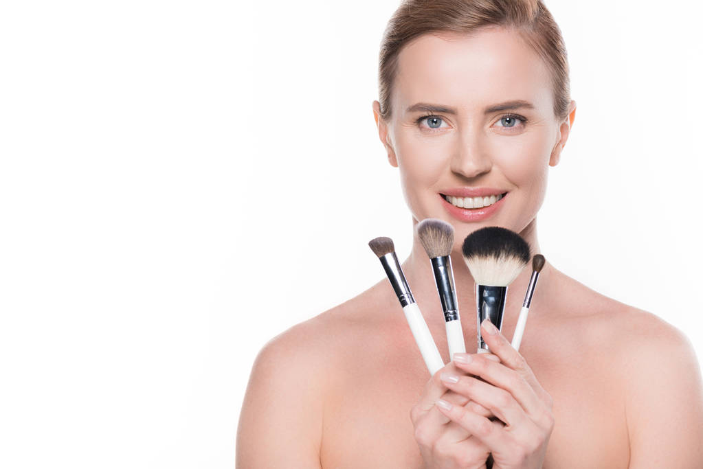 Женщина с чистой кожей с косметическими щетками, изолированными на белом
 - Фото, изображение