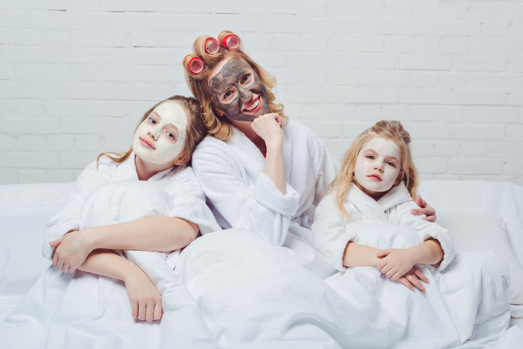 мать и дочери в постели с косметическими масками для лица
 - Фото, изображение