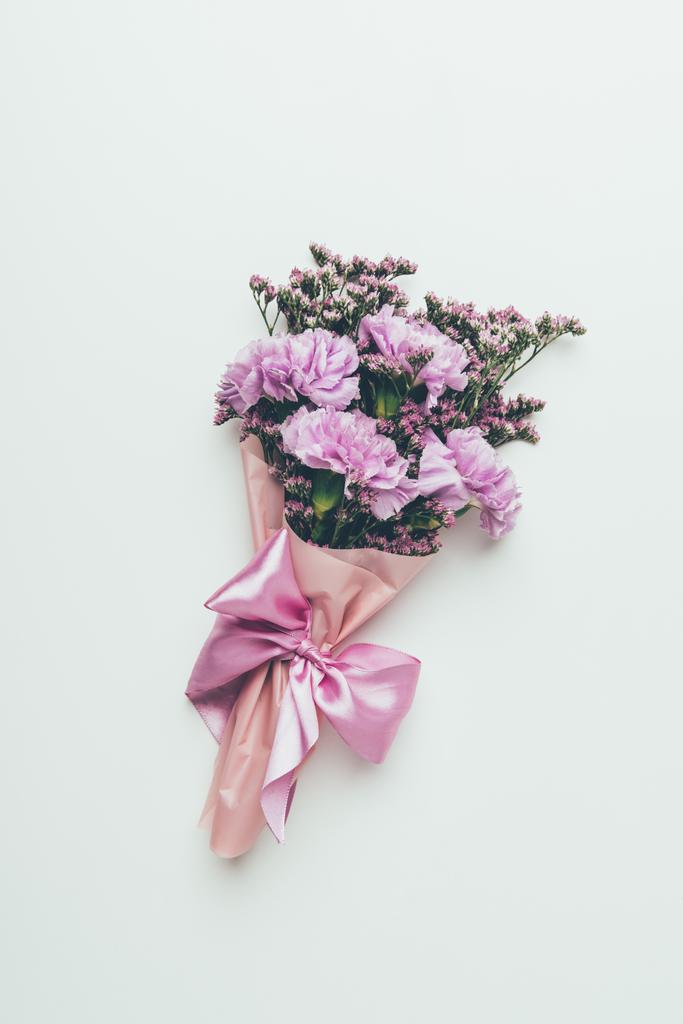 Widok z góry piękny przetargu elegancki kwiat bukiet z różową wstążką na szarym tle - Zdjęcie, obraz