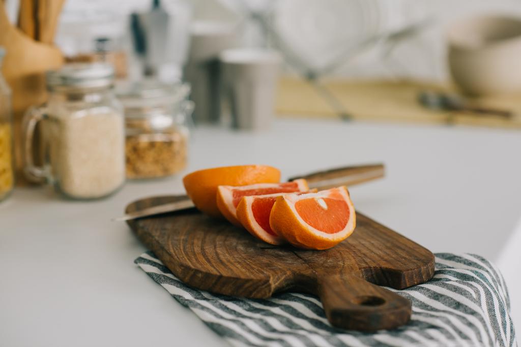 toranja cortada com faca na tábua de corte na cozinha
 - Foto, Imagem