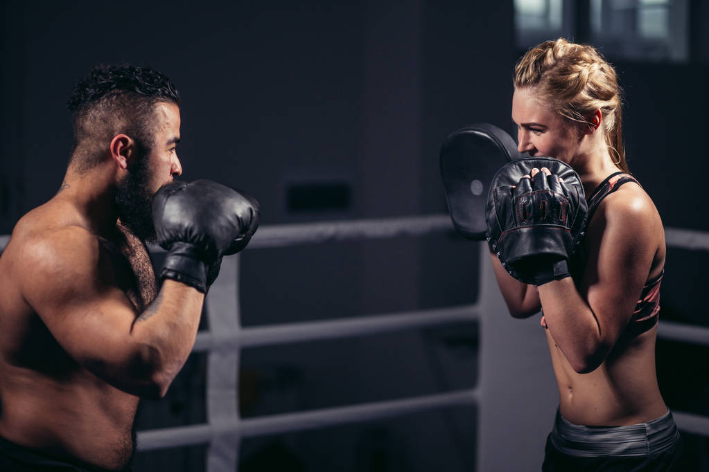 Boksen meisje training op boksen wanten gehouden door een master bokser - Foto, afbeelding