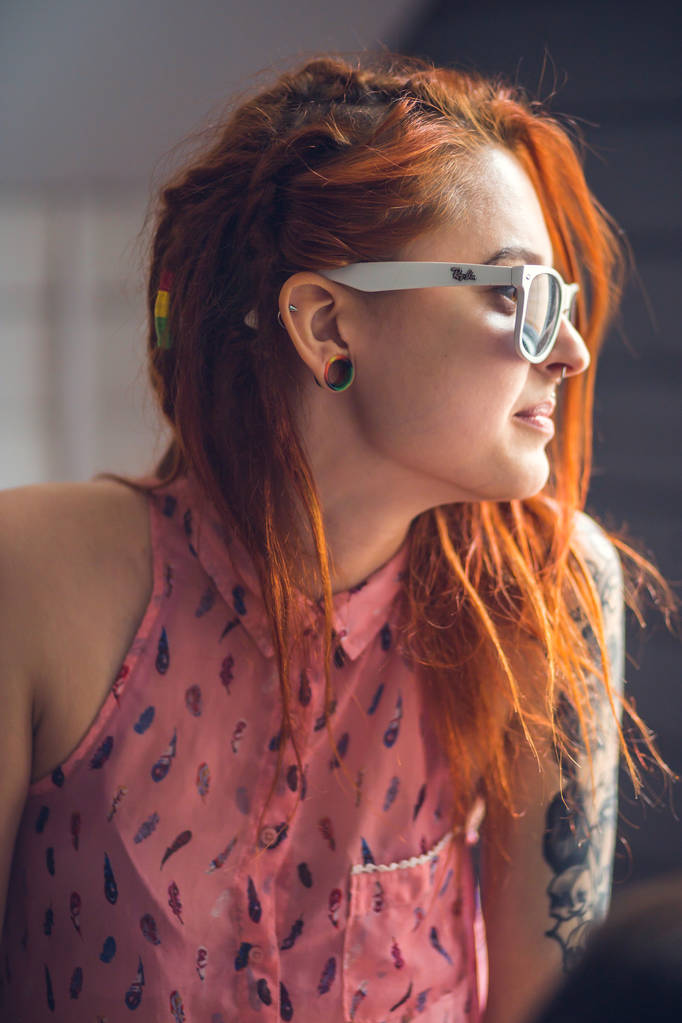 γυναίκα κοκκινομάλλα με γυαλιά και τατουάζ - Φωτογραφία, εικόνα