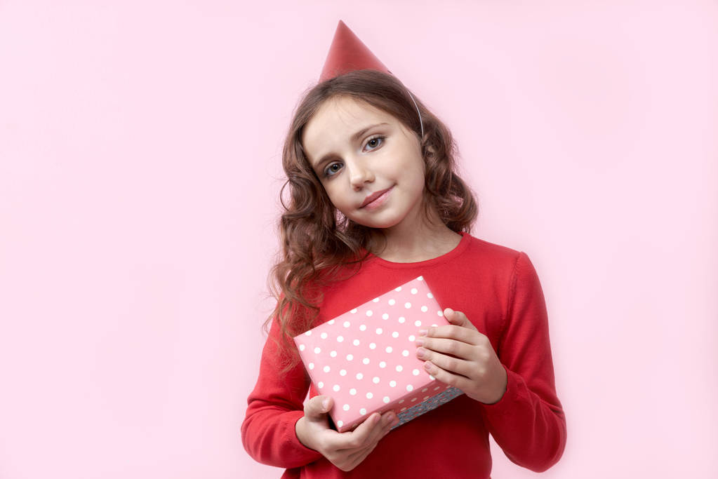 posiada ładny dziewczynce w czerwonej urodziny przed nią pudełko z szczęśliwy radosny wyraz i uśmiech - Zdjęcie, obraz