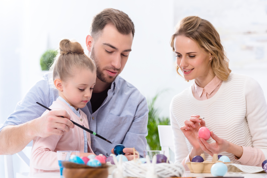 Kind und Eltern färben Eier für Ostern - Foto, Bild