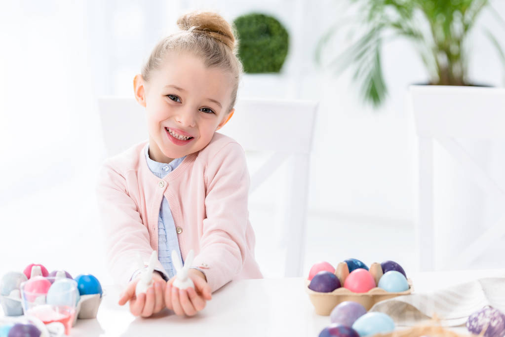 Παιδί κορίτσι δείχνει λαγουδάκι αγαλματίδια από τα αυγά του Πάσχα - Φωτογραφία, εικόνα
