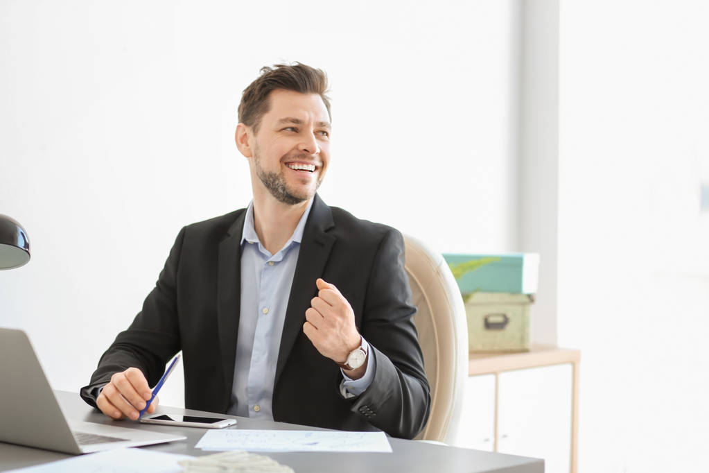 Happy businessman at table in office - Photo, Image